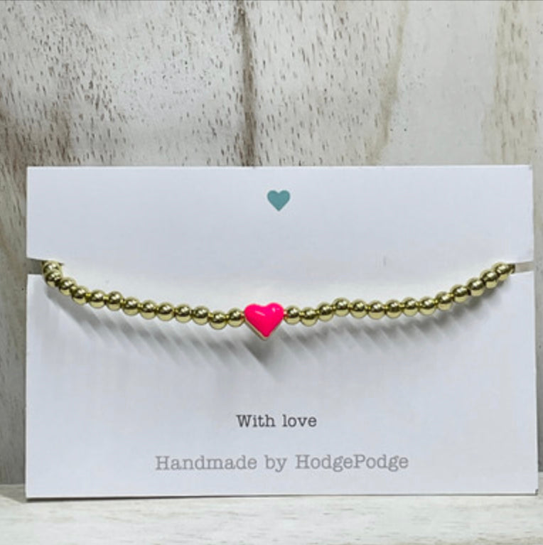 Gold bead bracelet with bright pink heart