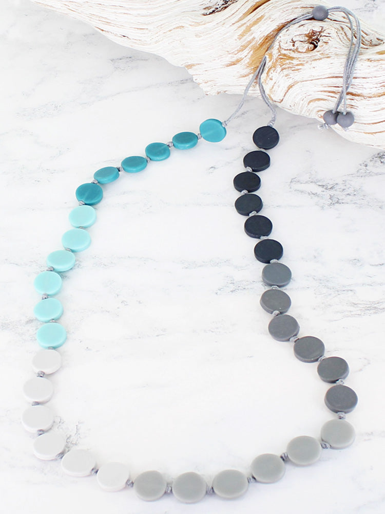 Long adjustable cord necklace. Blue tonal discs.