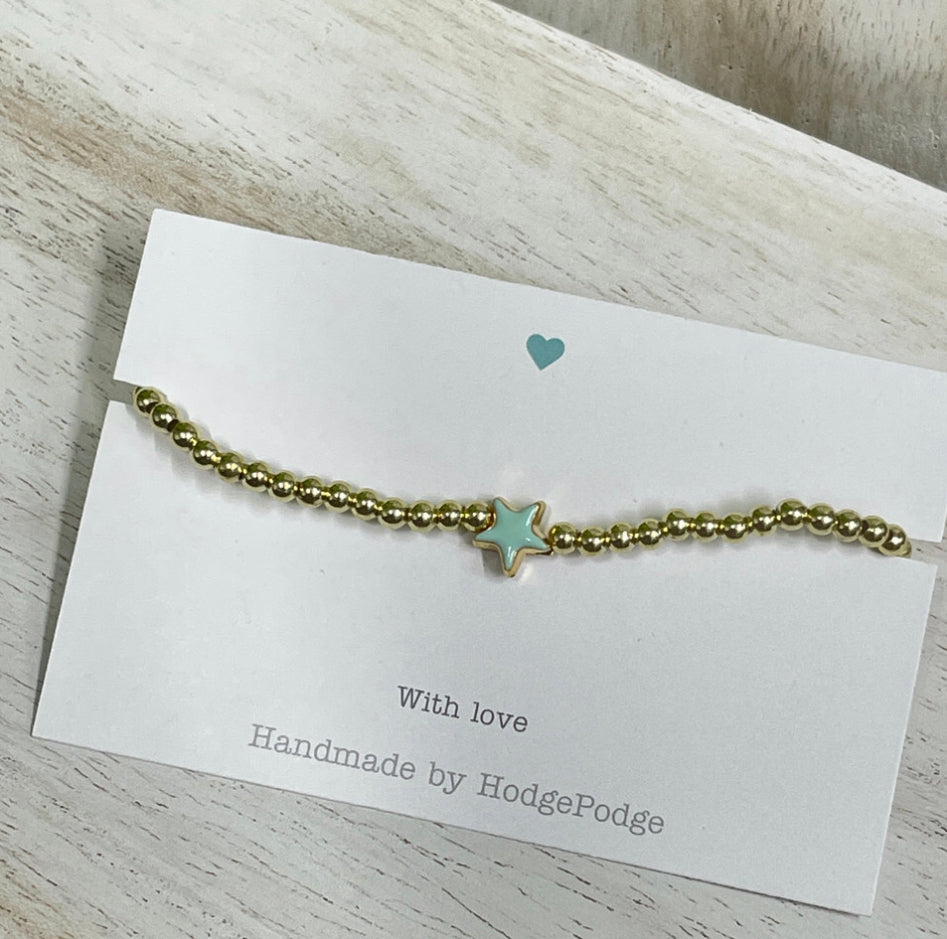 Gold bead bracelet with a jade enamel star.