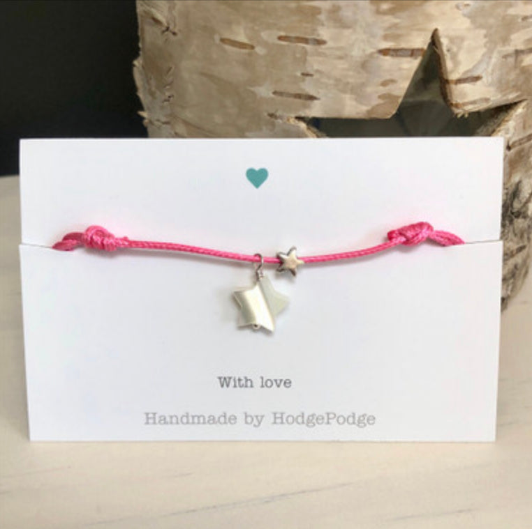 Adjustable cord bracelet with stars dark pink.