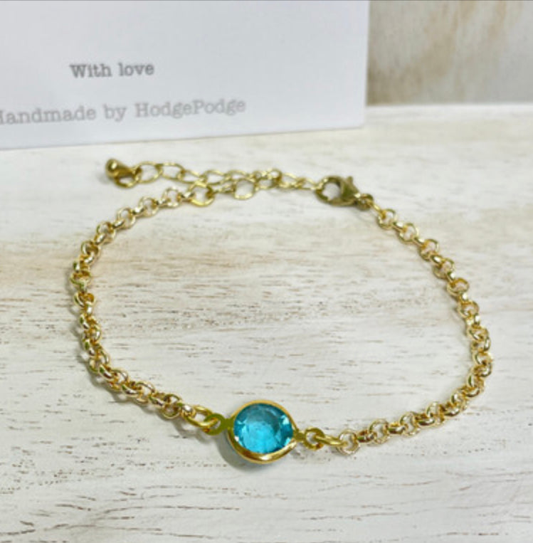 Gold belcher chain bracelet with blue glass link charm