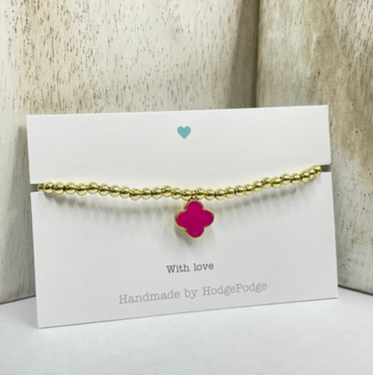 Gold bead bracelet with an enamel clover charm