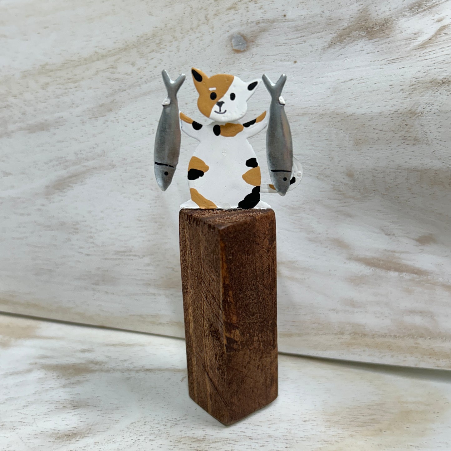 Cats on posts with fish dinner ornament.