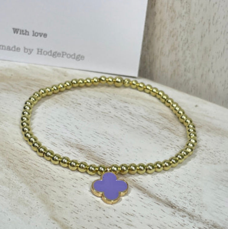 Gold bead bracelet with an enamel clover charm
