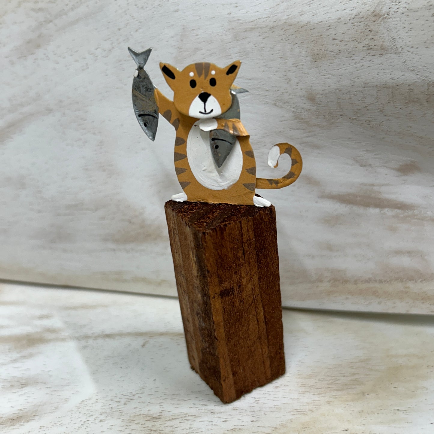 Cats on posts with fish dinner ornament.