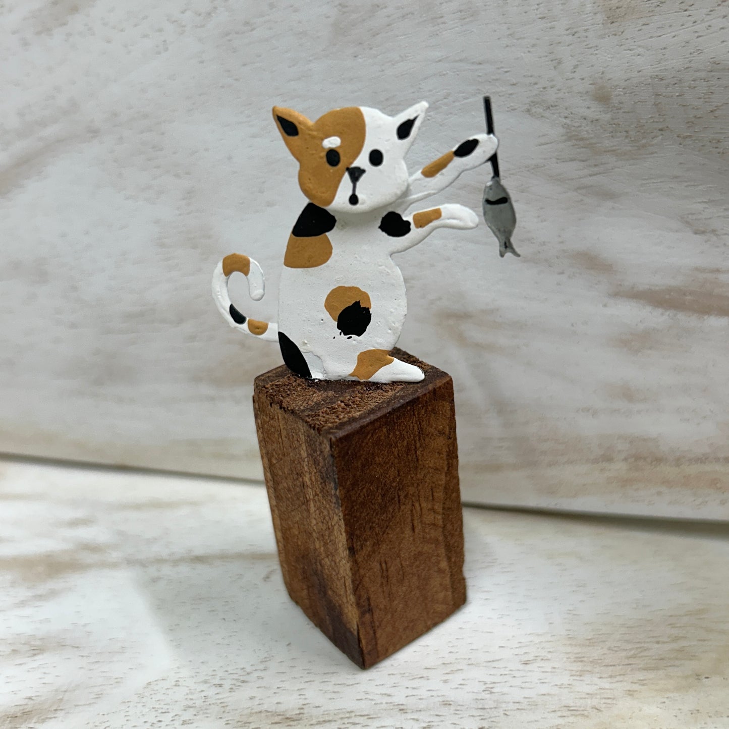 Cats on posts with fish dinner ornament.