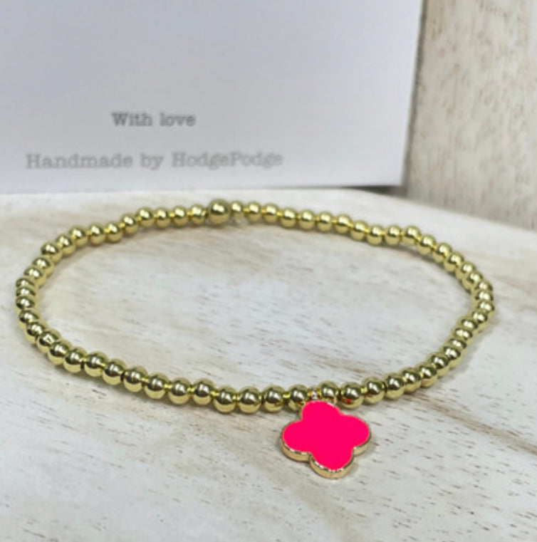 Gold bead bracelet with an enamel clover charm