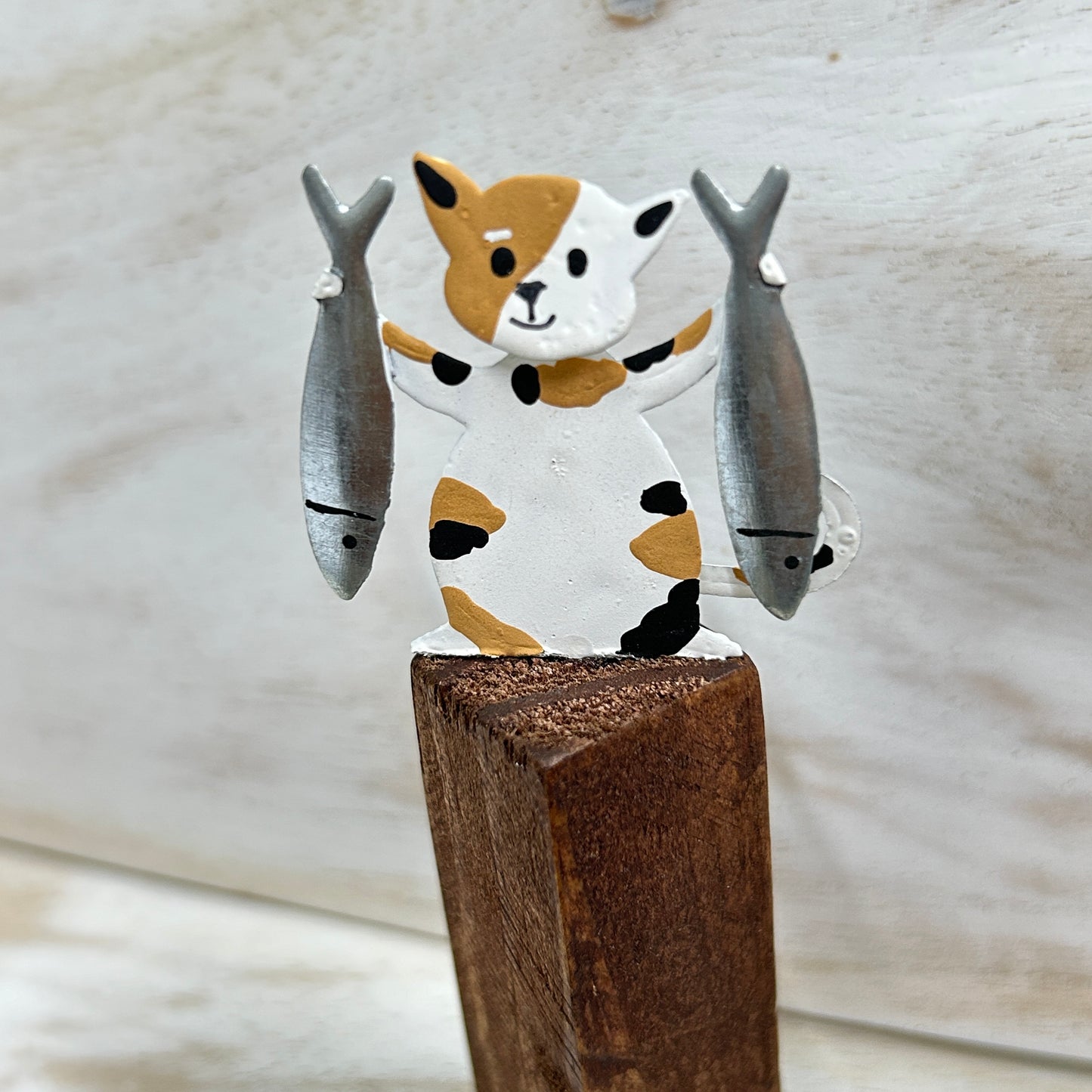 Cats on posts with fish dinner ornament.