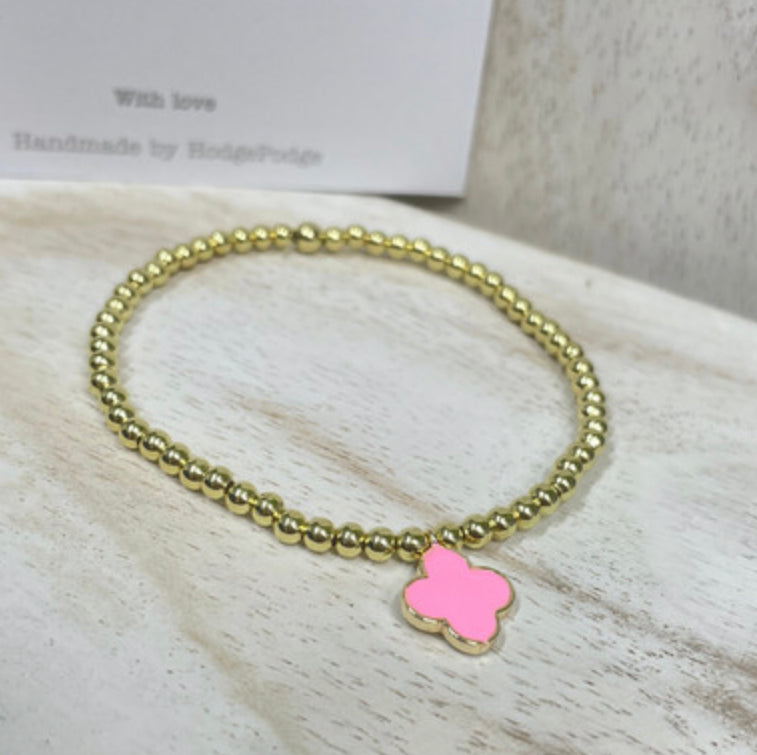 Gold bead bracelet with an enamel clover charm