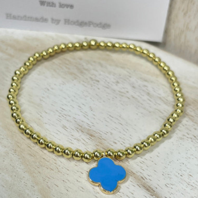 Gold bead bracelet with an enamel clover charm