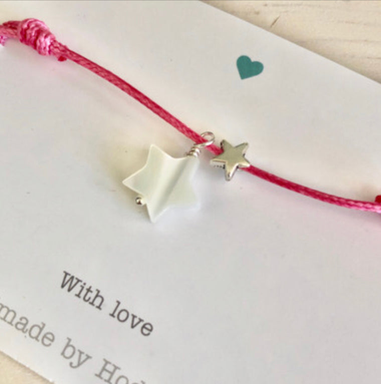 Adjustable cord bracelet with stars dark pink.