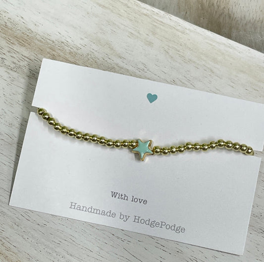 Gold bead bracelet with a jade enamel star.