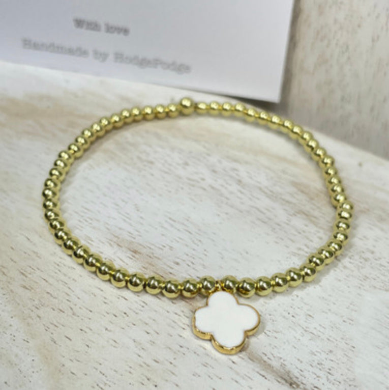 Gold bead bracelet with an enamel clover charm