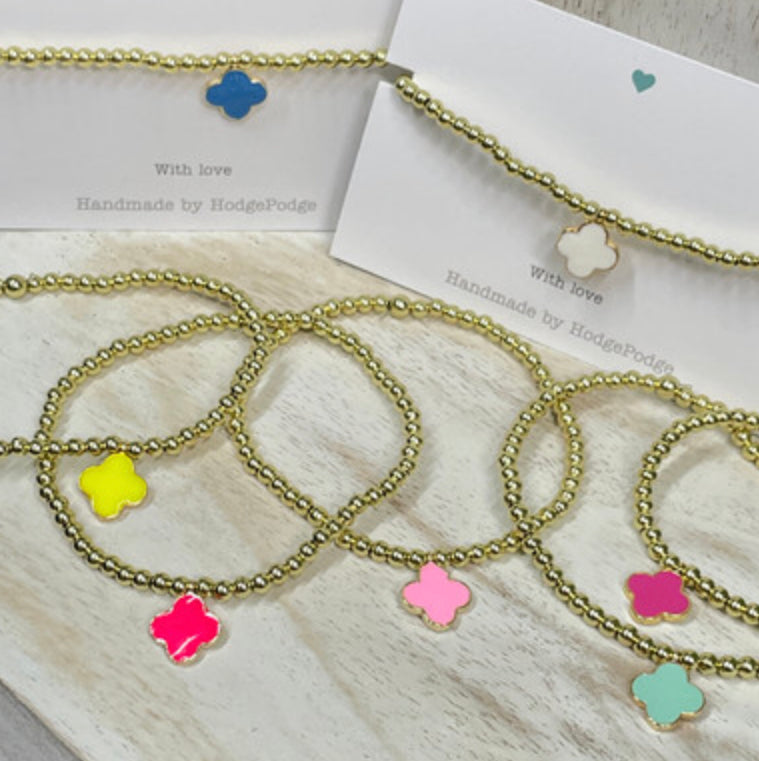 Gold bead bracelet with an enamel clover charm