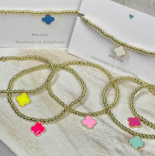 Gold bead bracelet with an enamel clover charm
