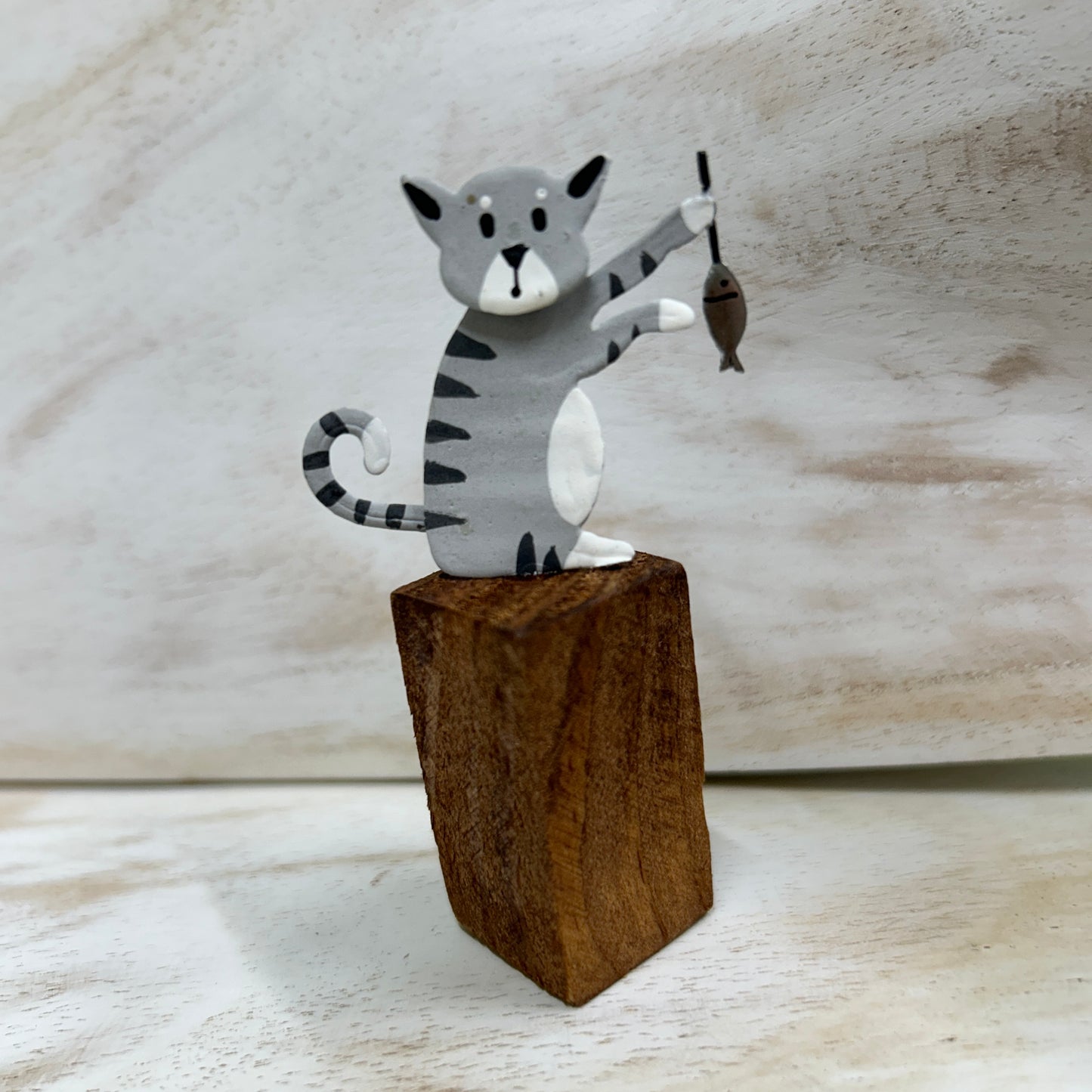 Cats on posts with fish dinner ornament.