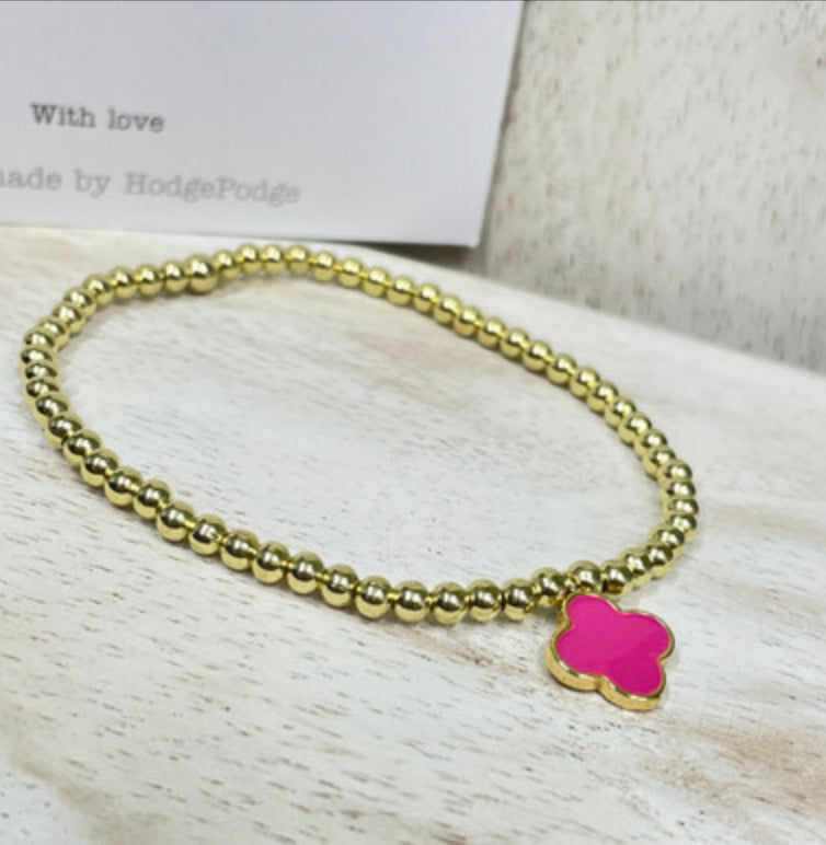 Gold bead bracelet with an enamel clover charm