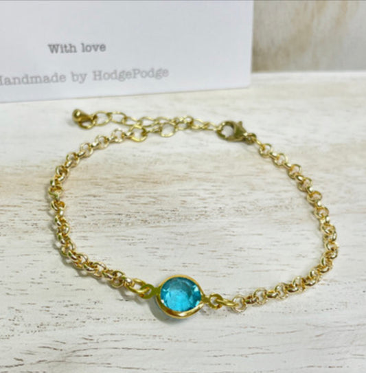 Gold belcher chain bracelet with blue glass link charm
