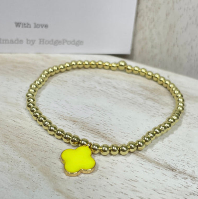 Gold bead bracelet with an enamel clover charm